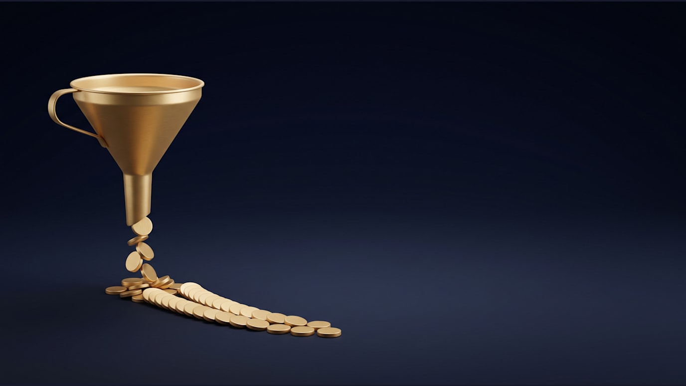 A funnel is pouring small gold discs into a narrowing row