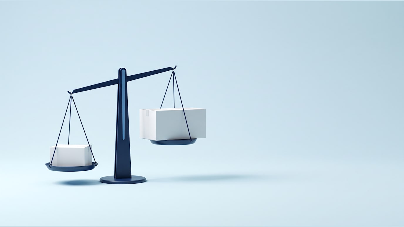 A navy balance scale tipping as two white boxes are weighed against each other
