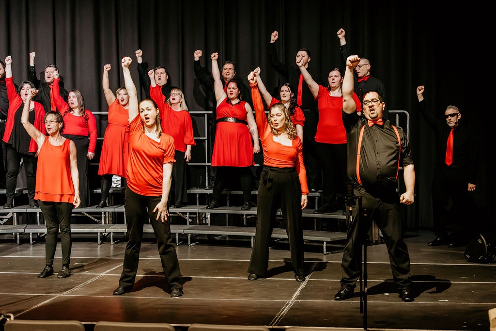 Voices of Broadway choir performing full choreography on stage